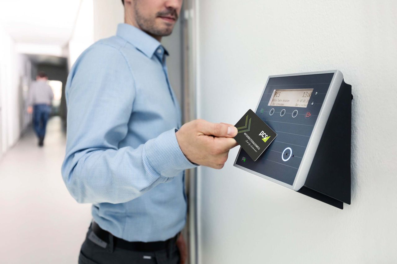 Services Businessman uses RFID card reader for secure office access, enhancing workplace security.