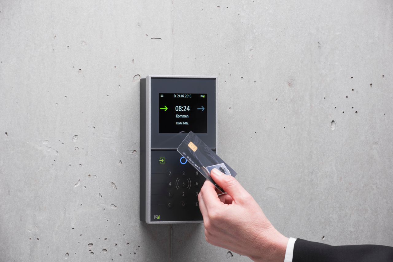 Services A businessman uses a secure card reader access system against a concrete wall.