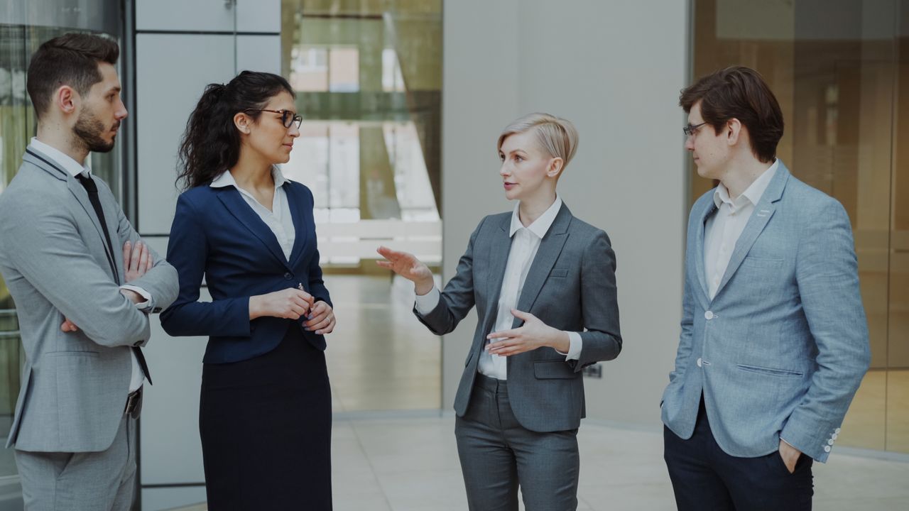 Crafting Captivating Headlines: Your awesome post title goes here Business professionals in suits discussing strategy in a modern office.