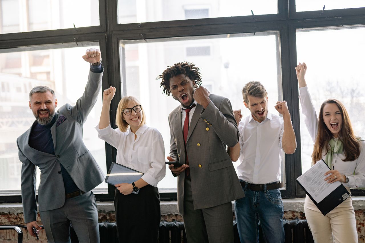 The Art of Drawing Readers In: Your attractive post title goes here Group of diverse professionals celebrating achievement in office setting with enthusiasm.