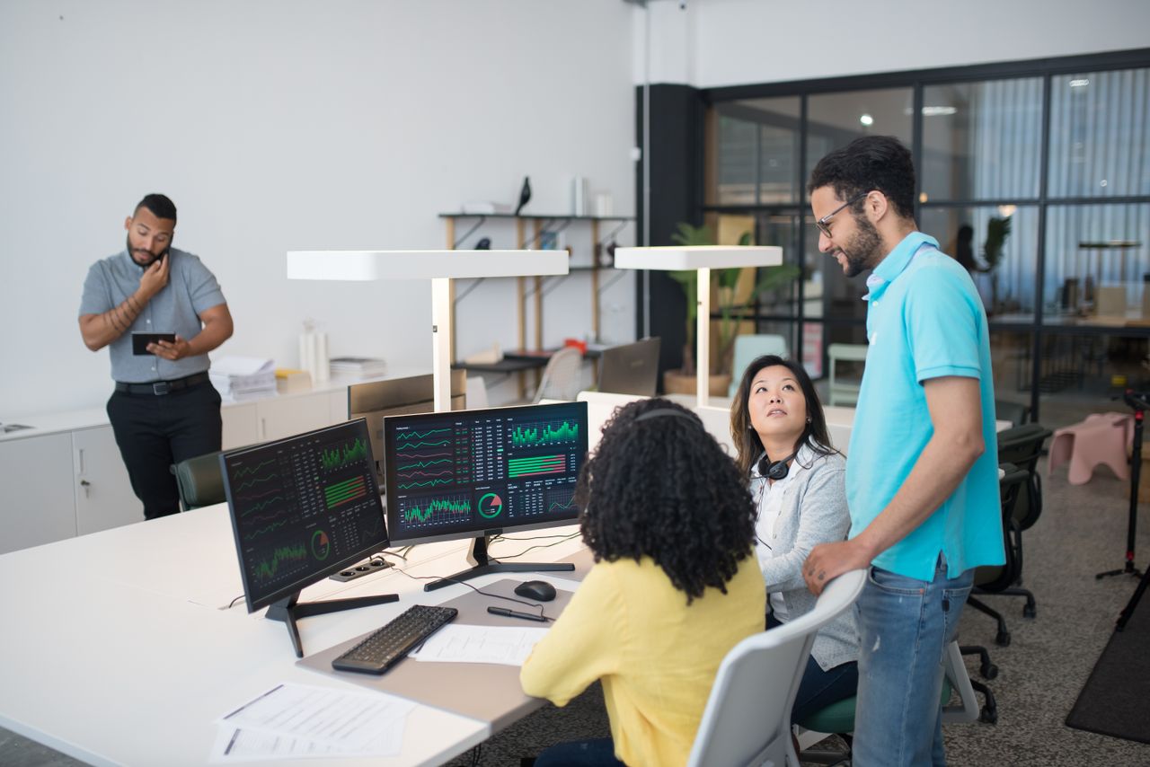 Mastering the First Impression: Your intriguing post title goes here Office employees collaborate on financial data at modern workspace, engaging in teamwork and communication.